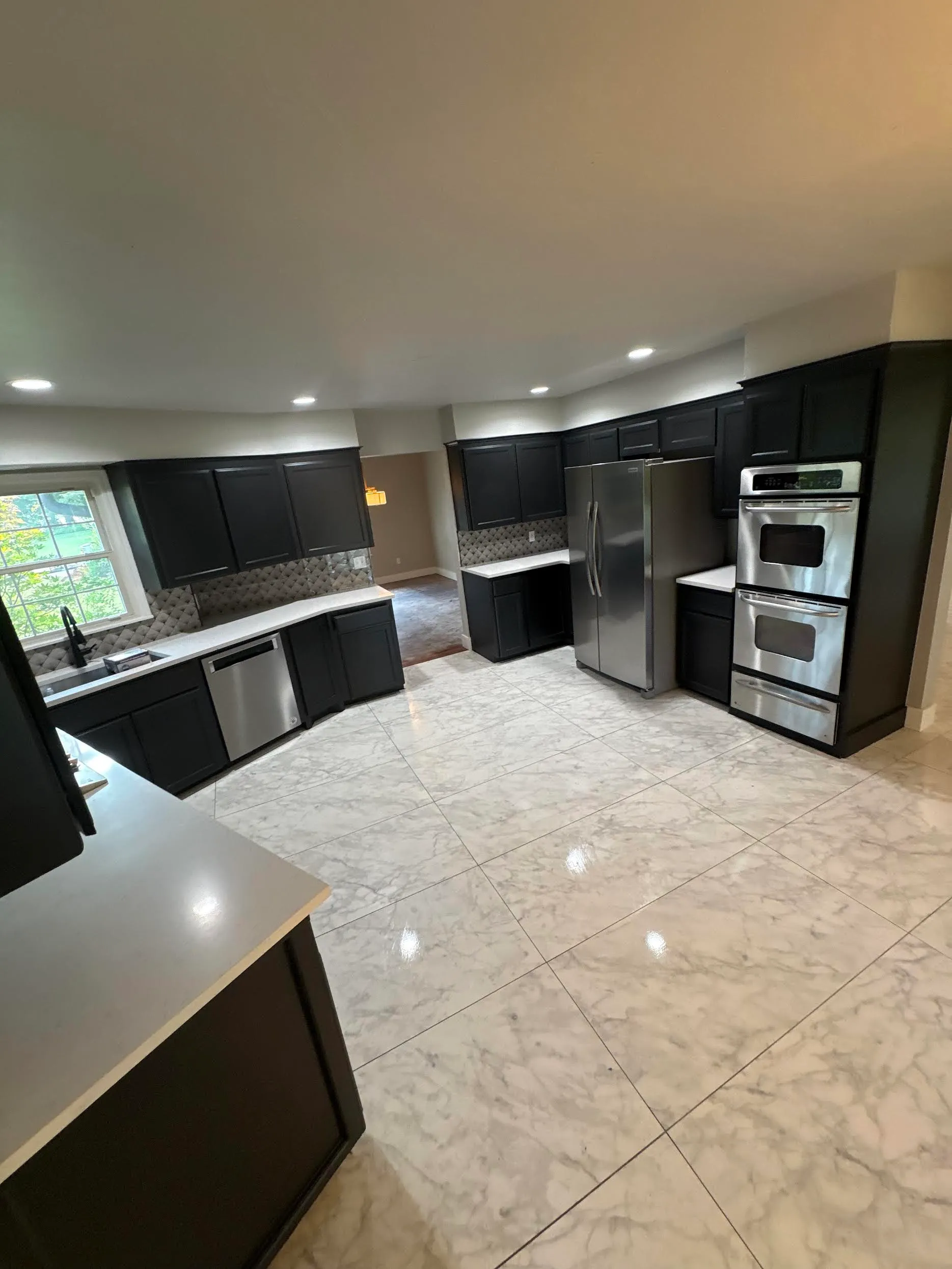 Kitchen at the Nichols Hills location, with dark cabinets, stone counters, and stainless steel appliances